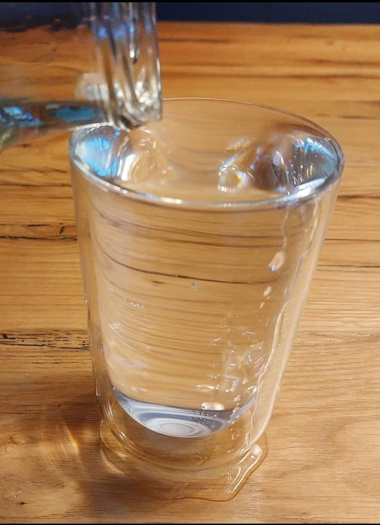 Ein überlaufendes Glas gefüllt mit Wasser