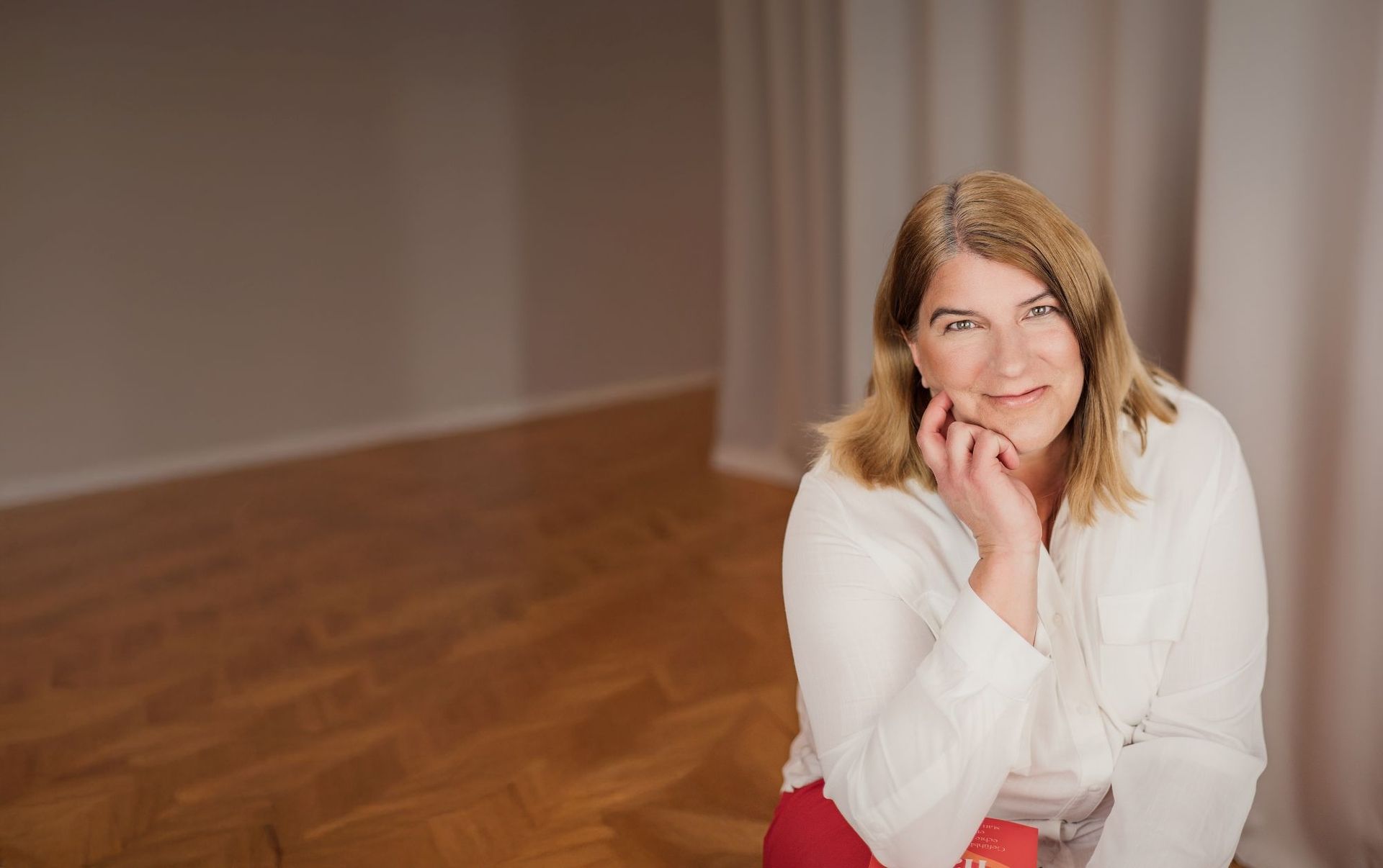 Alexandra Gillich sitzt in einem offenen Raum und lächelt