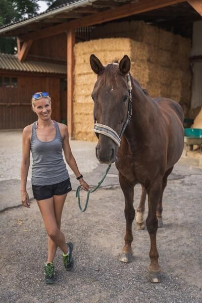 Trainerin Carmen mit einem Pferd am Zaum
