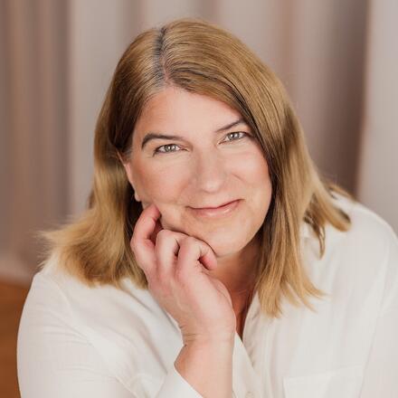 Alexandra Gillich lächelt und stützt Ihr Gesicht auf Ihre Hand